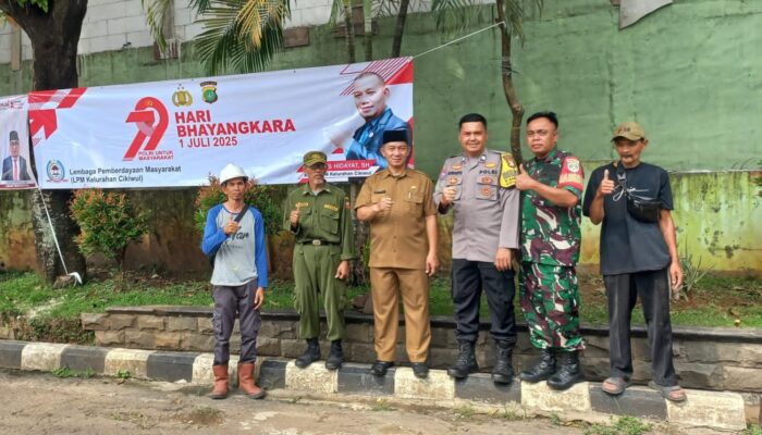Sinergitas Tiga Pilar Pasang Spanduk HUT Bhayangkara ke-79 Kelurahan Cikiwul